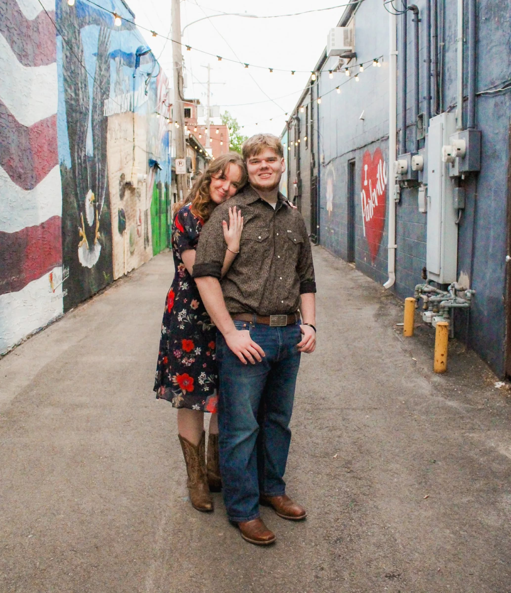 Couple standing together in a mural-lined alley